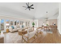Bright living room with hardwood floors, large windows, a ceiling fan, and an adjacent dining area at 1904 S Union Pl, Lakewood, CO 80228