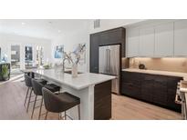 A contemporary kitchen showcases stainless steel appliances, white countertops, and stylish bar stool seating at 1735 E 18Th Ave, Denver, CO 80218
