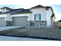 Charming townhome featuring stone accents, a neutral color palette, and an attached two car garage at 3431 N Denali St, Aurora, CO 80019