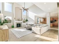 Bright living room featuring a fireplace, soaring ceilings, and a seamless open-concept design at 3532 Springbriar Dr, Castle Rock, CO 80109