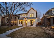 Charming two-story home with white siding, a metal roof, inviting front porch, and manicured lawn at 652 S Race St, Denver, CO 80209