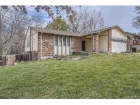 Charming brick home featuring an attached two-car garage and well-maintained front lawn at 11029 W 65Th Way, Arvada, CO 80004