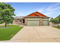 Charming two-story home featuring a three-car garage and a well-manicured lawn at 5193 Rustic Ave, Firestone, CO 80504