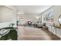 Bright living room with hardwood floors, a large window, and cozy seating area at 1155 W 4Th Ave, Broomfield, CO 80020