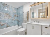 Updated bathroom with marble blue tile, modern vanity, mirror and shower-tub combination at 1021 Carr St # 37, Lakewood, CO 80214