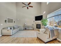 Spacious living room with a fireplace, large windows, and comfortable seating area at 226 N Millbrook St, Aurora, CO 80018