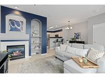 Inviting living room with fireplace, sofa, and charming blue accent wall at 5555 E Briarwood Ave # 1404, Centennial, CO 80122