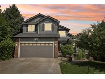 Charming two-story home with a well-manicured lawn and beautiful landscaping, complemented by a two car garage at 15948 E 106Th Pl, Commerce City, CO 80022