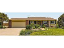 Charming single-Gathering home featuring a well-manicured lawn and lovely landscaping at 702 Windmill Pl, Highlands Ranch, CO 80126