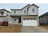 Charming two-story home with gray siding, a brick facade and a two car garage at 3352 N Buchanan Way, Aurora, CO 80019