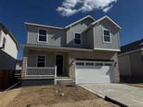 Charming two-story home with a stone and siding facade and a pristine white garage door at 3352 N Buchanan Way, Aurora, CO 80019