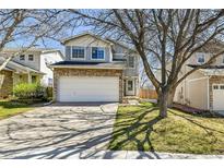 Charming two-story home featuring a stone facade and attached two-car garage, set against a clear blue sky at 8050 Bryant St, Westminster, CO 80031