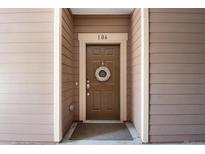Inviting brown front door with a decorative wreath and unit number 106 at 10056 W Unser Dr # 106, Littleton, CO 80127