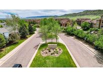 Street view featuring the community entrance sign and tree-lined streets at 10056 W Unser Dr # 106, Littleton, CO 80127