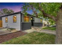 Charming single-story home with a well-maintained lawn, gray paint, and lovely landscaping at 2701 Barnhart St, Thornton, CO 80229
