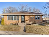 Brick ranch home with a ramp and a well-maintained lawn at 1338 Aspen Pl, Longmont, CO 80501