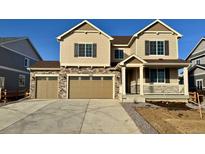 Two-story house with tan siding, three-car garage, and a small front yard at 25041 E 38Th Ave, Aurora, CO 80019