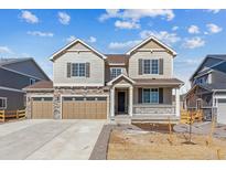 Charming two-story home featuring a three-car garage, stone accents, and a welcoming front porch at 25041 E 38Th Ave, Aurora, CO 80019