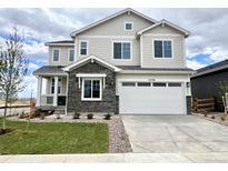 Beautiful two-story home featuring stone accents, a two-car garage, and manicured landscaping at 24798 E 40Th Ave, Aurora, CO 80019