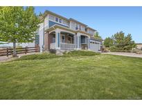 Charming two-story home with a welcoming front porch and well-manicured lawn in a peaceful neighborhood at 7485 S Jackson Gap Way, Aurora, CO 80016