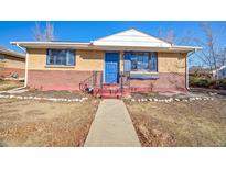 Charming single-story home with a brick facade, a blue front door, and a well-maintained walkway at 8520 Franklin Dr, Denver, CO 80229