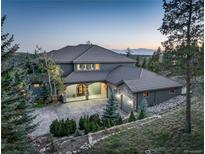Stunning exterior elevation of a luxury home with porte-cochere and a circular driveway at 28154 Belle Mont Trl, Conifer, CO 80433