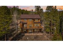 Stunning two-story home with a large deck, surrounded by lush greenery and scenic mountain views at 278 Snowshoe Cir, Breckenridge, CO 80424