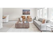 Bright and airy living room featuring comfortable seating, a large coffee table and an eye-catching art piece at 4821 W 102Nd Ave, Westminster, CO 80031