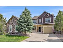 Beautiful two-story home with a well-manicured lawn and mature landscaping at 23298 Barnsley Ln, Parker, CO 80138