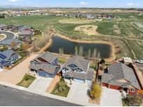 A neighborhood aerial view includes homes, a pond, green space and other neighborhood amenities at 2757 Stallion Way, Mead, CO 80542