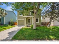 Charming two-story home with an attached garage, lush lawn, and mature trees providing shade and curb appeal at 4267 W Kenyon Ave, Denver, CO 80236