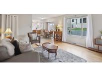 Bright living room featuring hardwood floors, a cozy sitting area, and large windows for ample natural light at 1799 S Lee St # B, Lakewood, CO 80232