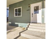 Inviting front entrance with concrete steps and light green siding on a charming single Gathering home at 6491 Barnacle Ct, Boulder, CO 80301