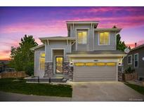 Charming two-story home with stone accents and a two-car garage at dusk at 10685 Cherrybrook Cir, Highlands Ranch, CO 80126
