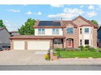 Charming brick and siding two-story home with a spacious three-car garage and solar panels on the roof at 12752 W Dakota Ave, Lakewood, CO 80228