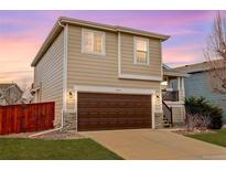 Charming two-story home with a brown garage door, stone accents, and a cozy front porch at 9879 Saybrook St, Highlands Ranch, CO 80126