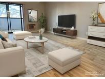 Bright living room featuring stylish furniture, modern decor, and a sliding door for natural light at 1011 S Ironton St # 107, Aurora, CO 80012