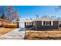 Cozy brick home featuring a driveway leading to a one car garage and manicured front yard at 6140 Dudley St, Arvada, CO 80004