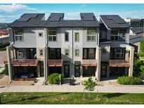 Modern townhomes showcasing solar panels, balconies, landscaped grounds, and covered outdoor seating areas at 10154 Belvedere Loop, Lone Tree, CO 80124
