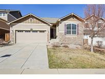 Charming home featuring a two-car garage, stone accents, and a well-maintained lawn at 24437 E Powers Ave, Aurora, CO 80016