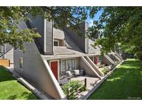 Charming townhouse featuring a red door, inviting patio, and well-maintained landscaping at 5250 S Huron Way # 3-205, Littleton, CO 80120