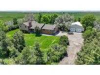 Expansive home with a large garage and a lush green lawn at 1335 S Kio St, Watkins, CO 80137