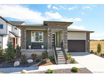 Charming home featuring stone accents, a covered porch, and a well-maintained front yard at 8360 Snake River St, Littleton, CO 80125