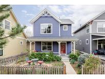 Charming blue two-story home with a cozy front yard and inviting red front door at 9124 E 29Th Pl, Denver, CO 80238