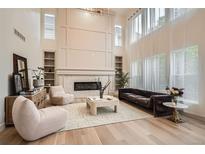 Bright living room with floor-to-ceiling fireplace, hardwood floors, and clerestory windows at 22367 Quail Run Dr, Parker, CO 80138
