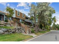 Charming townhouse exterior with rock landscaping and wooden stairs leading to the entrance at 2574 E Geddes Ave, Centennial, CO 80122