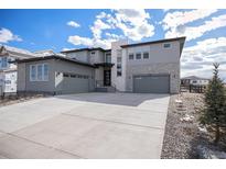 Beautiful two-story home with gray siding, stone accents, a spacious driveway, and a two-car garage at 3564 Doubletrack Ln, Castle Rock, CO 80108