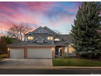 Charming two-story home with a well-manicured lawn and three car garage at sunset at 1792 W Kettle Ave, Littleton, CO 80120