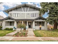 Charming gray two-story home featuring a well-maintained lawn, inviting entrance and welcoming front porch at 1401 S Clarkson St, Denver, CO 80210