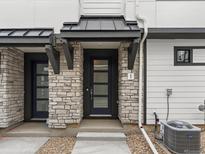 Stylish townhouse front door with stone accents, black trim, and a modern design at 2036 S Holly St # 4, Denver, CO 80222
